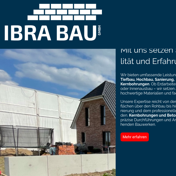 Neubau mit Ziegelmauer, blauen Himmel und Baustellenmaterialien im Vordergrund.